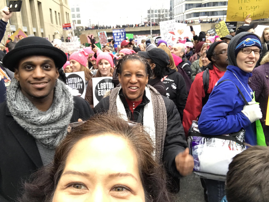 Marching in a crowd, selfie (eyes) with black man and woman behind me and sea of pink hats